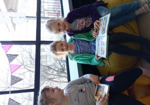 Dziewczynki oglądają książki siedząc na kolorowych siedziskach